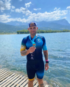 triathlète de charenton triathlon avec une médaille devant un lac des alpes